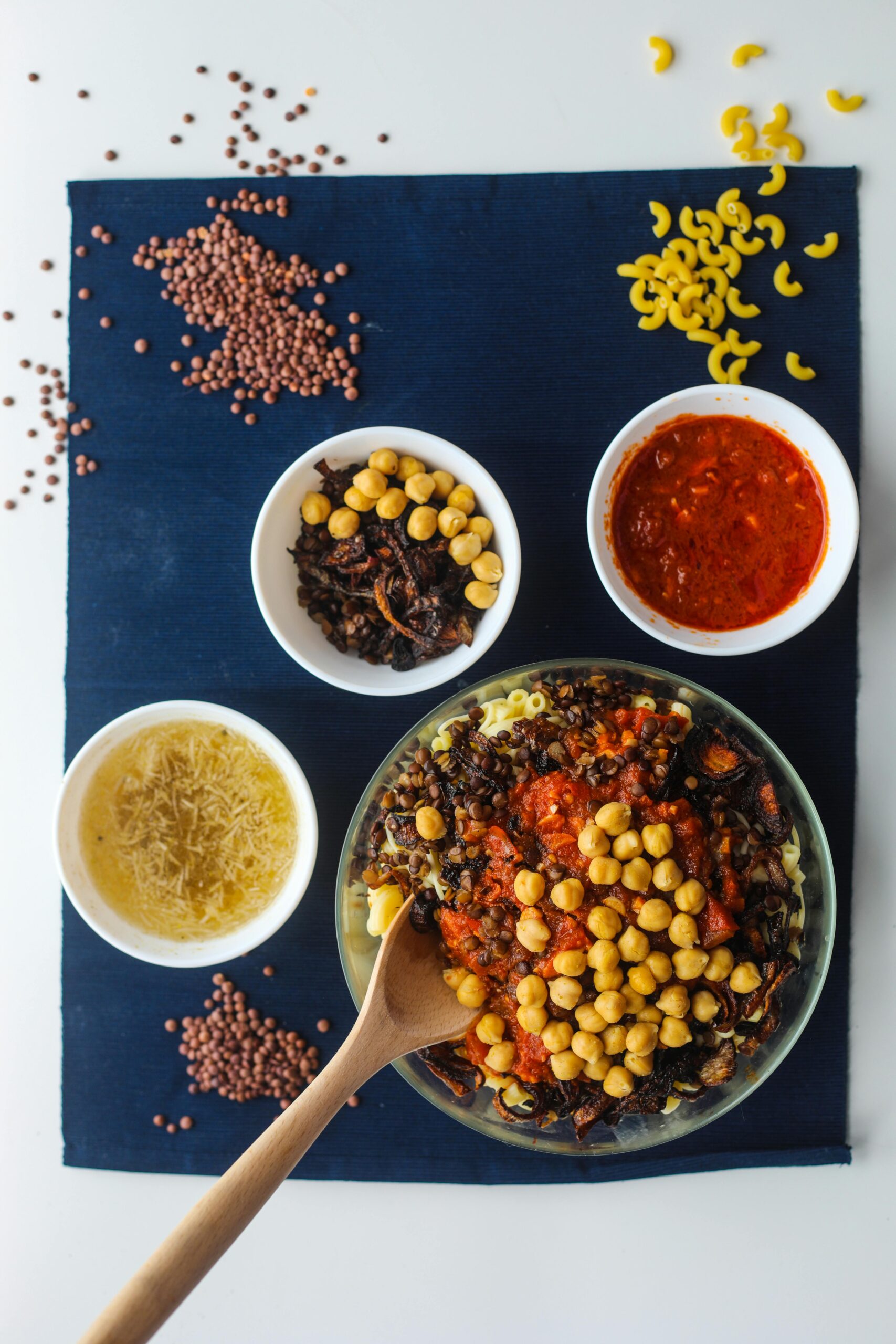 A top view of traditional Egyptian Koshari with ingredients on display, showcasing diverse textures and colors.